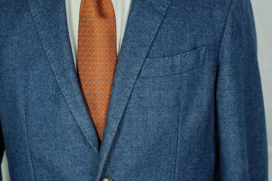Blue blazer with a red patterned tie on a gray background