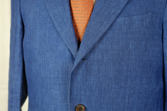 Blue suit jacket with a button and orange tie peeking out